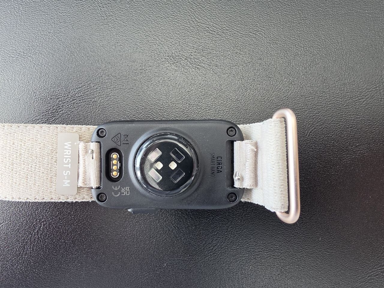 Retro del modulo Garmin Cirqa con il sensore ottico, i contatti di ricarica e l'etichetta della taglia S-M