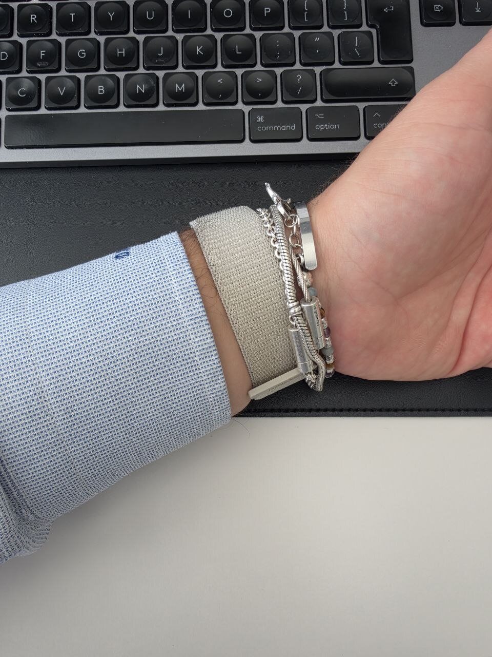 Garmin Cirqa al polso visto di lato, accanto a bracciali in argento