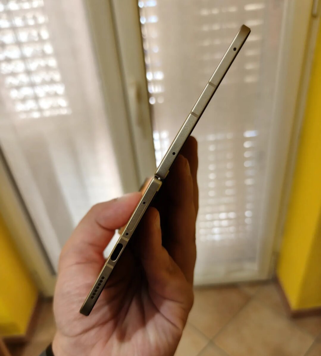 OPPO Find N6 aperto visto di taglio, sottilissimo, tenuto in mano