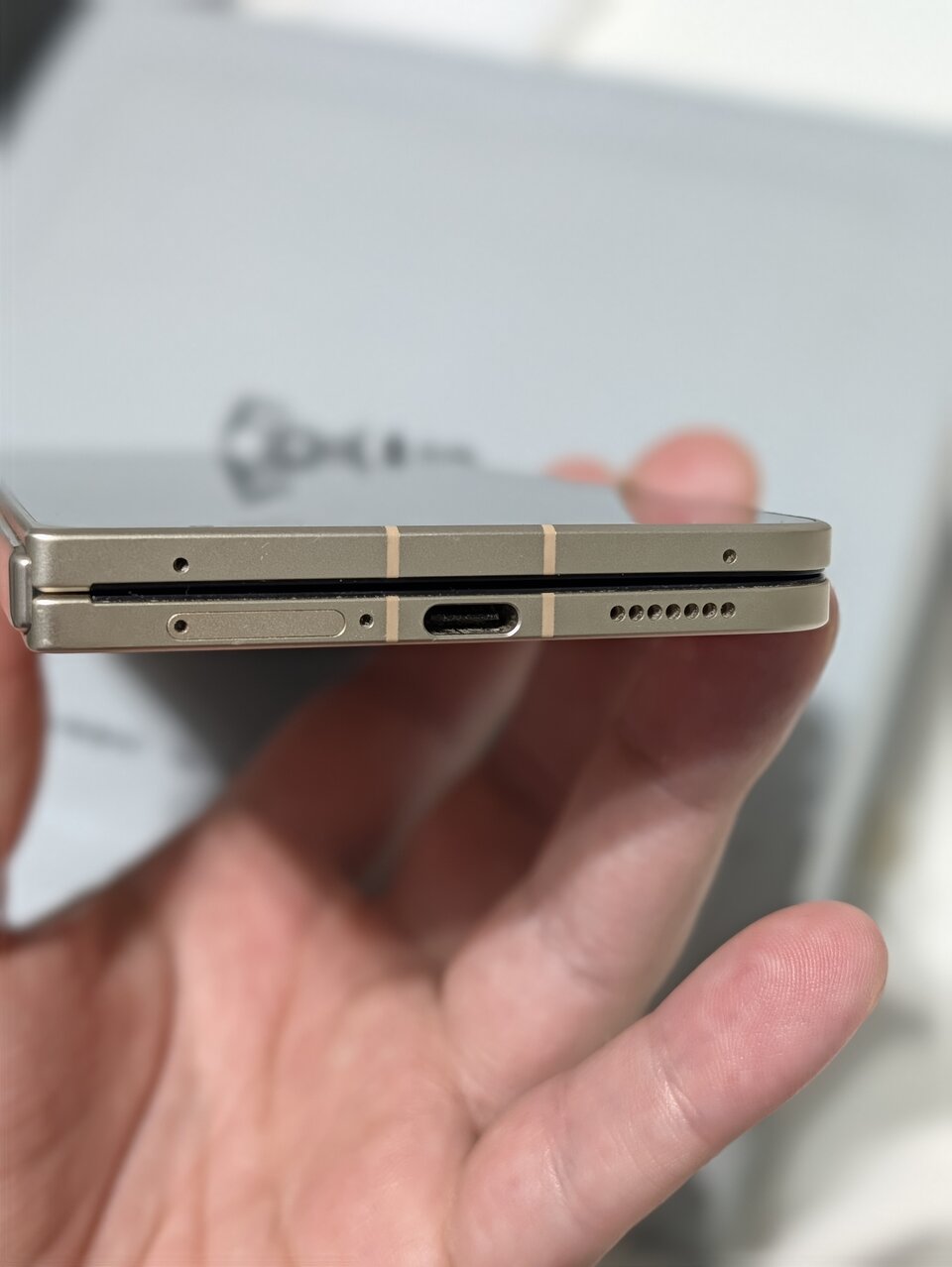 Bordo inferiore dell'OPPO Find N6 chiuso con carrellino SIM, porta USB-C e griglia dell'altoparlante