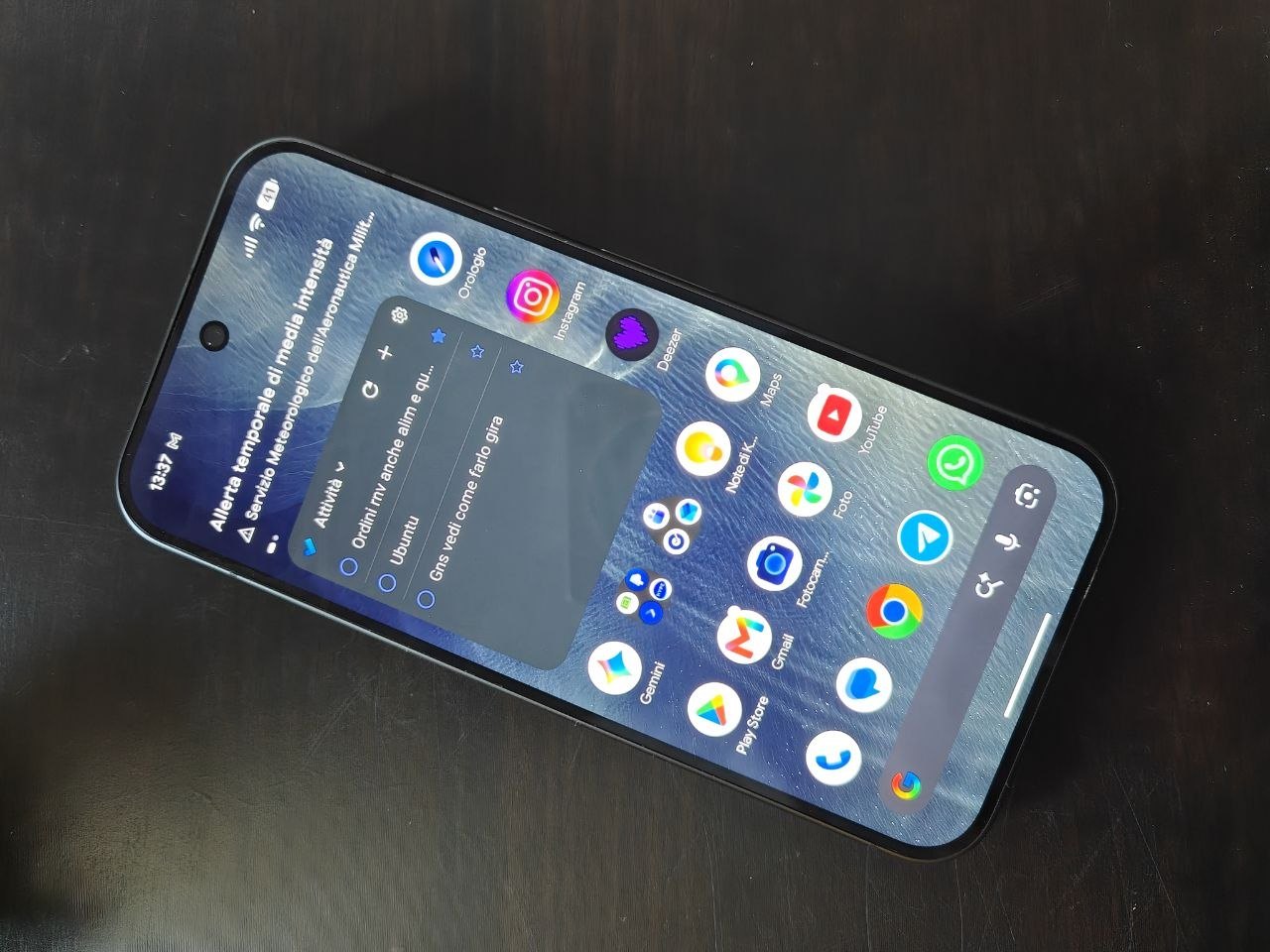 Display del Pixel 11 Pro acceso con la schermata Home, appoggiato sulla scrivania