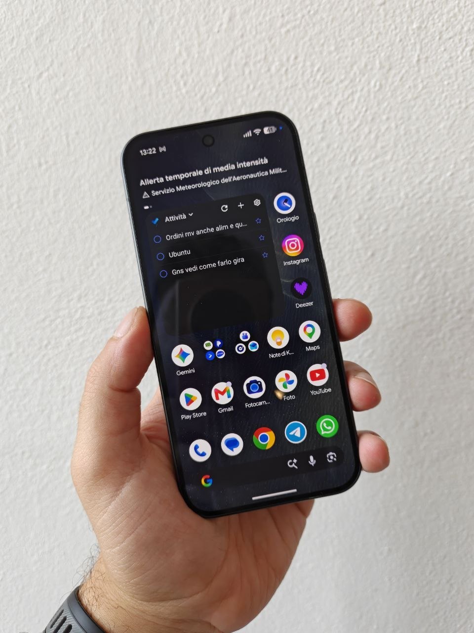 Pixel 11 Pro tenuto in mano con la schermata Home di Android e i widget